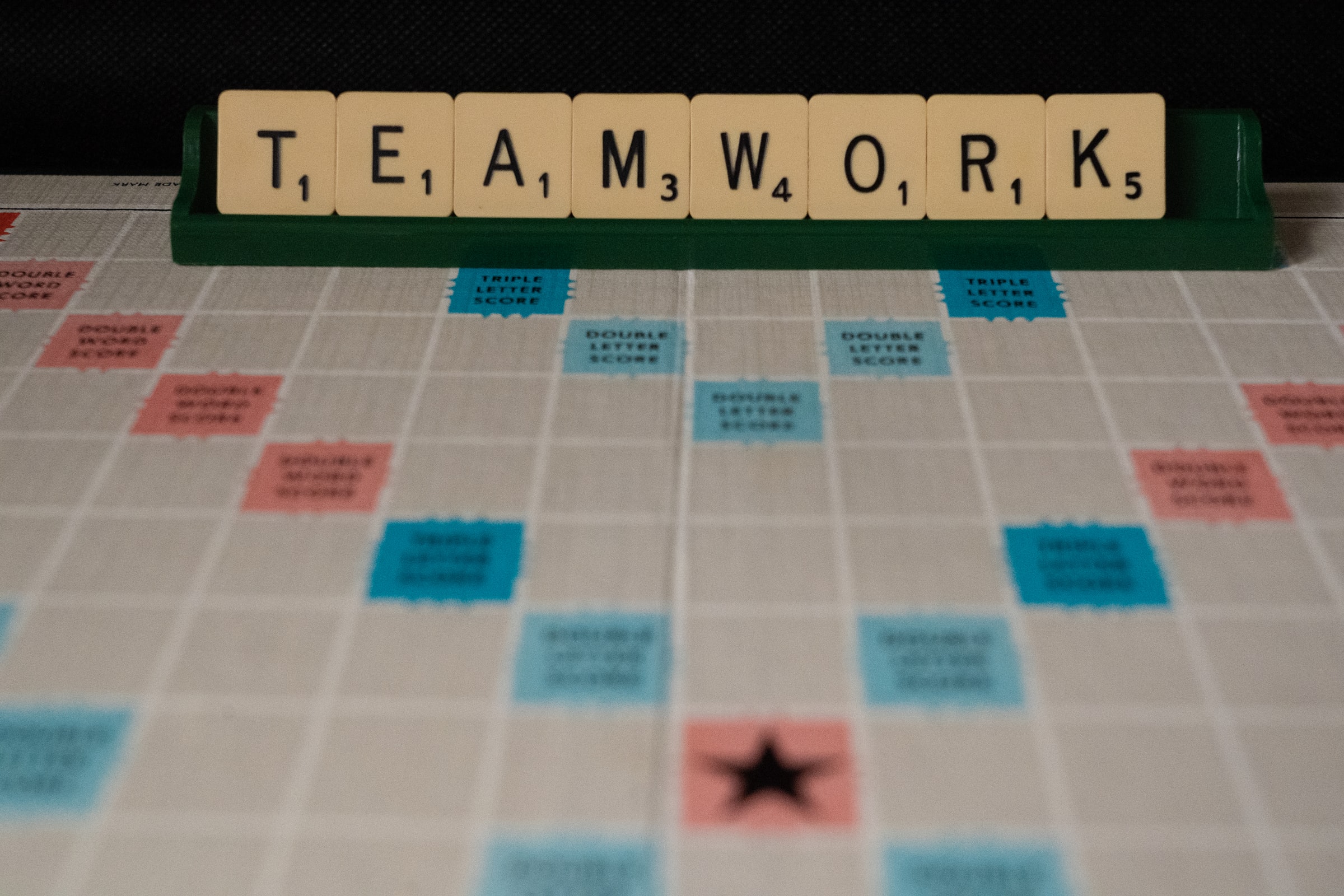 Scrable board that spells TEAMWORK for smoothly updating supplier specifications